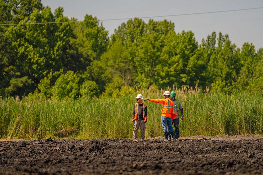 Three field personnel wearing PPE on a construction site